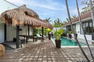 a resort with a swimming pool and a straw umbrella at Villa Ruku-Ruku - Modern 1BR Villa with AC Living Room & Private Pool - French Style Interior in Kerobokan