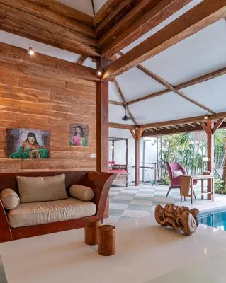a living room with a couch and a pool at Villa Gambar - Comfortable Modern Mix 3BR Villa with Large Private Pool, 10 Minutes to the Beach in Canggu