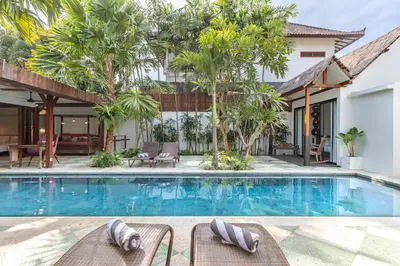 a villa with a swimming pool and a resort at Villa Gambar - Comfortable Modern Mix 3BR Villa with Large Private Pool, 10 Minutes to the Beach in Canggu