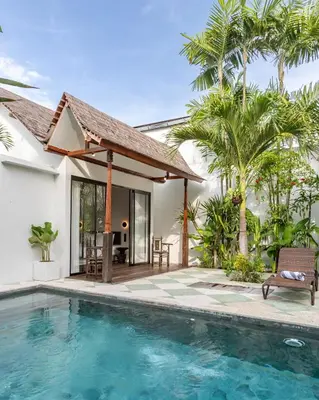 a villa with a swimming pool and a house at Villa Gambar - Comfortable Modern Mix 3BR Villa with Large Private Pool, 10 Minutes to the Beach in Canggu