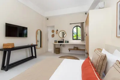 a bedroom with a bed and a tv on a wall at Casa Adem - Modern & Trendy 3BR Villa in Seminyak, 10 Minutes to the Beach with Private Pool in Seminyak