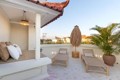 a patio with two chairs and a table on a balcony at Casa Adem - Modern & Trendy 3BR Villa in Seminyak, 10 Minutes to the Beach with Private Pool in Seminyak
