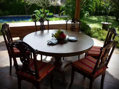a wooden table and chairs with a bowl of fruit on it at Villa Hanani in Jimbaran