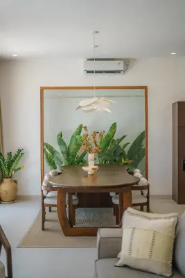 a room with a table with a vase of flowers on it at Villa Umaju - Contemporary Minimalist 2BR Villa in Umalas! in Canggu