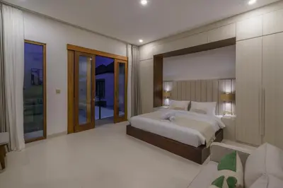 a bedroom with a large bed and a balcony at Villa Umaju - Contemporary Minimalist 2BR Villa in Umalas! in Canggu