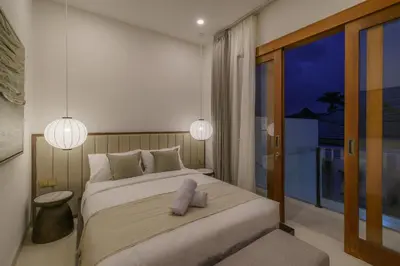 a bedroom with a large bed and a balcony at Villa Umaju - Contemporary Minimalist 2BR Villa in Umalas! in Canggu