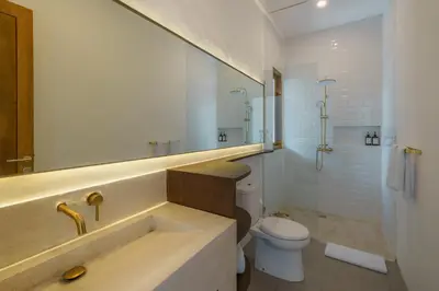 a white bathroom with a sink and a toilet at Villa Umaju - Contemporary Minimalist 2BR Villa in Umalas! in Canggu