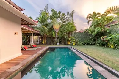 a swimming pool with a wooden deck next to a house at Villa Telma - Charming 2BR Villa in Central Seminyak, Walking Distance to Eat Street in Seminyak