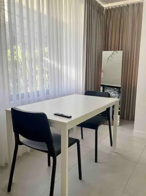 a white table and two chairs in a room at The Drupadi Apartments Studio Peka in Seminyak