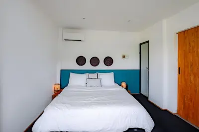 a bedroom with a large bed with two plates on the wall at House Sawah - Beautiful & Stylish 3BR Home with Jacuzzi Near Umalas and Seminyak in Kerobokan