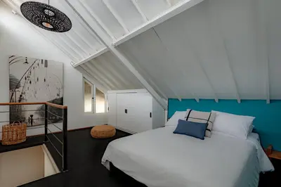 a bedroom with a white bed and a blue wall at House Sawah - Beautiful & Stylish 3BR Home with Jacuzzi Near Umalas and Seminyak in Kerobokan