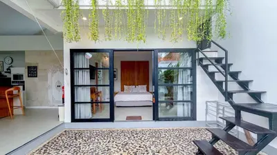 a living room with a staircase and a bedroom at Villa Elea - Bright & Modern 2BR Villa in Seminyak with Private Pool and Sunset Rooftop in Seminyak