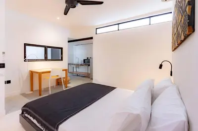 a bedroom with a large bed and a table at Town House REX in Kuta