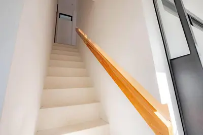 a staircase in a white building with a door at Town House REX in Kuta