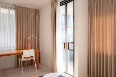 a room with a desk and a window at Town House REX in Kuta