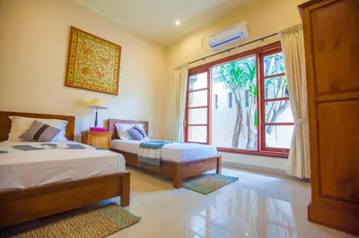 a bedroom with two beds and a large window at Vibrant Getaway in Seminyak: Villa Buyaya in Seminyak