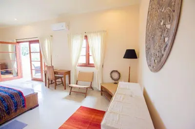 a bedroom with a bed and a desk and a table at Vibrant Getaway in Seminyak: Villa Buyaya in Seminyak