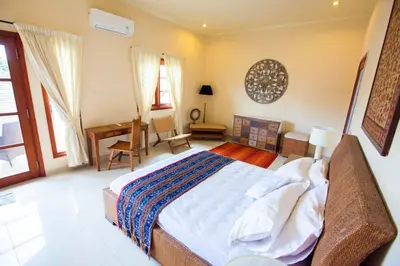a bedroom with a bed and a desk in it at Vibrant Getaway in Seminyak: Villa Buyaya in Seminyak