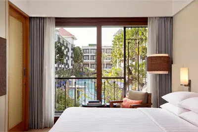 a bedroom with a bed and a large window at Courtyard by Marriott Bali Seminyak Resort in Seminyak
