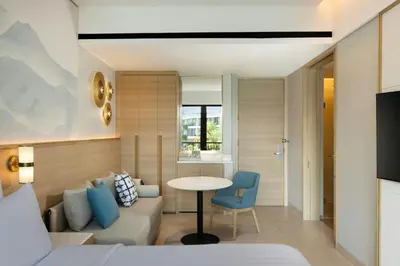 a hotel room with a bed and a table and a couch at Courtyard by Marriott Bali Seminyak Resort in Seminyak