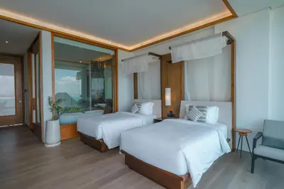 a hotel room with two beds and a chair at Beyond The Sea - Luxe Sea View Villa in Jimbaran in Jimbaran