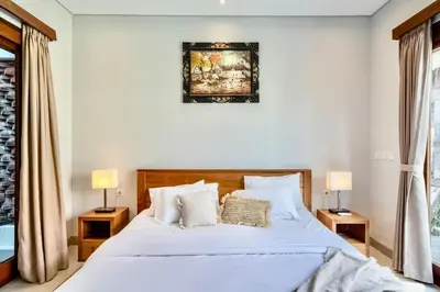 a bedroom with a large white bed with two lamps at Exclusive 2BR Villa with bathroom en suite and privat Pool in Kerobokan