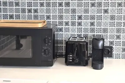 a microwave and a cell phone next to a wall at Seminyak Dream 1 bedroom villa with private pool in Seminyak