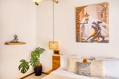 a room with a bed and a painting on the wall at Villa Tango - New Luxurious 7BDR Prime Location in Seminyak