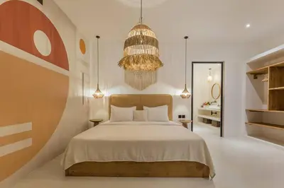 a bedroom with a large bed and a chandelier at Villa Alamanda Maya Seminyak center 2 bedr with private Pool in Seminyak