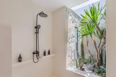 a bathroom with a shower with a plant mural on the wall at Villa Alamanda Maya Seminyak center 2 bedr with private Pool in Seminyak