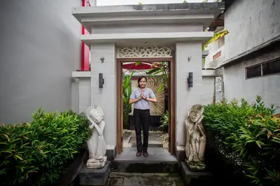 a man standing in the doorway of a building at Angkul Angkul Beach Inn Kuta by Kamara in Kuta