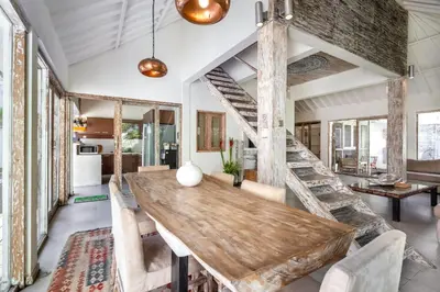 a dining room with a large wooden table and chairs at Villa Oberoi in Seminyak