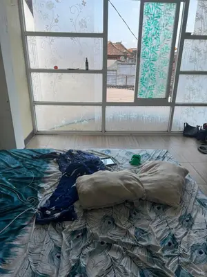 an unmade bed in a room with a window at Villa Sipaling in Pesanggaran