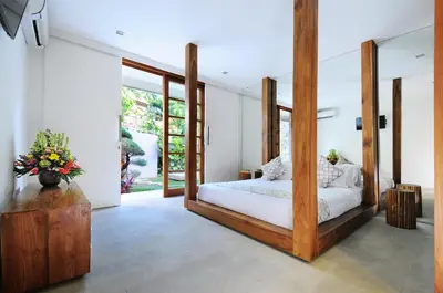 a bedroom with a large bed with a wooden frame at 4BR Villa Minggu - Minggu Villas Seminyak in Seminyak