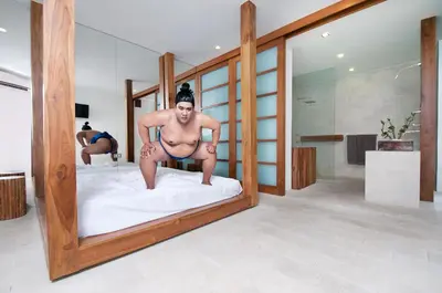 a man in a bathing suit on a bed in a room at 4BR Villa Minggu - Minggu Villas Seminyak in Seminyak