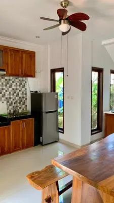a kitchen with a table and a ceiling fan at St.Regina Bali 3 Bedroom Villa in Nusa Dua