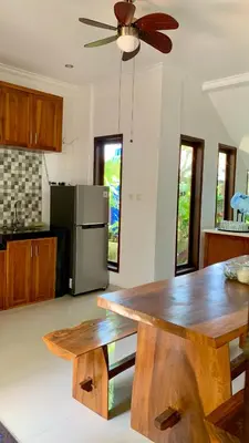 a kitchen with a wooden table and a refrigerator at St.Regina Bali 3 Bedroom Villa in Nusa Dua