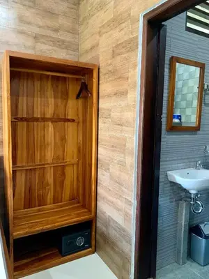 a bathroom with a sink and a wooden wall at St.Regina Bali 3 Bedroom Villa in Nusa Dua