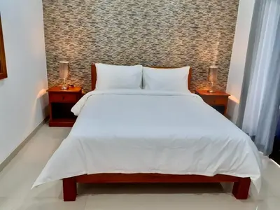 a bedroom with a large white bed with two night stands at St.Regina Bali 3 Bedroom Villa in Nusa Dua