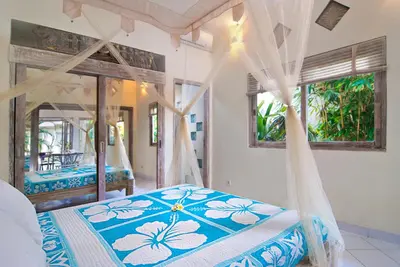a bedroom with a bed with a canopy at Villa Domus Dua in Seminyak