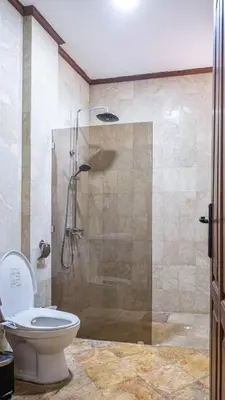 a bathroom with a shower with a toilet in it at Aiwan Hostel & Luggage storage in Sanur