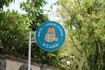 a sign for the university of akron in front of trees at Aiwan Hostel & Luggage storage in Sanur