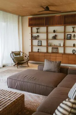 a living room with two beds and a chair at Sandhouse Berawa in Canggu