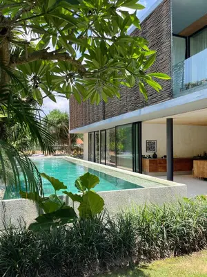 an external view of a house with a swimming pool at Sandhouse Berawa in Canggu
