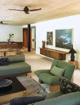 a living room with green furniture and a wooden ceiling at Sandhouse Berawa in Canggu