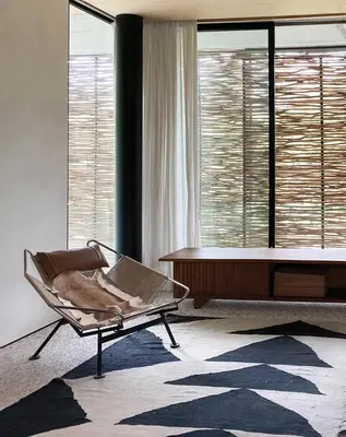 a living room with a bed and a chair and a table at Sandhouse Berawa in Canggu