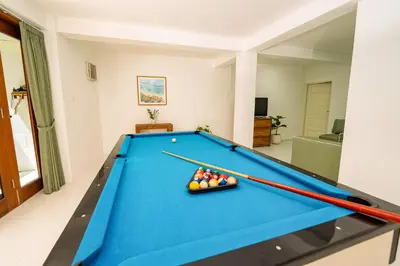 a pool table in a living room with two cuesticks at Spacious 3 BR Villa with private pool and Billiards in Seminyak