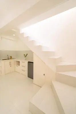a white kitchen with white floors and white stairs at Spacious 3 BR Villa with private pool and Billiards in Seminyak