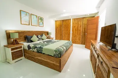 a bedroom with a bed and a flat screen tv at Spacious 3 BR Villa with private pool and Billiards in Seminyak