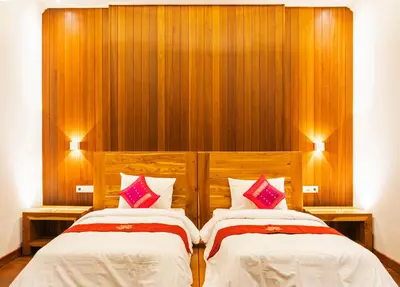 two beds in a room with wood paneling at Winy Estate - Luxury Villa with Rooftop Jacuzzi in Canggu